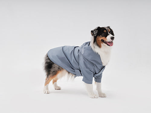 Side profile of light blue dog raincoat showing adjustable toggles on sleeves and hem