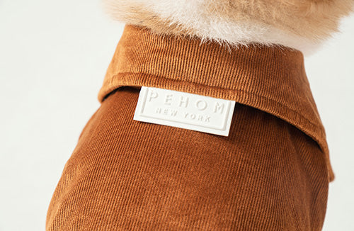 Close up of premium PEHOM logo embroidery and ribbed neck on the orange shirt