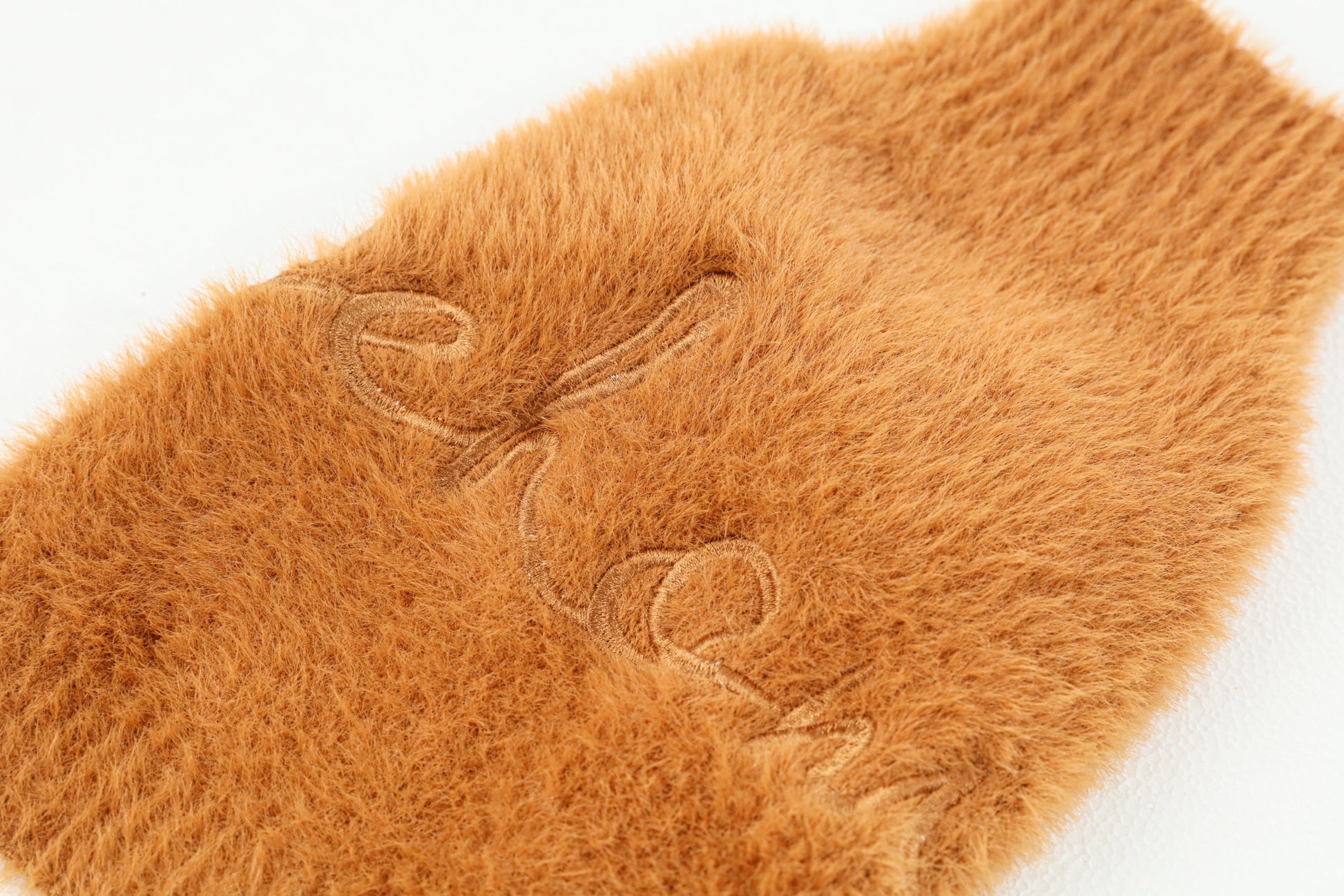 Close up of the ultra-soft, cloud-like fuzzy texture on the orange winter dog sweater